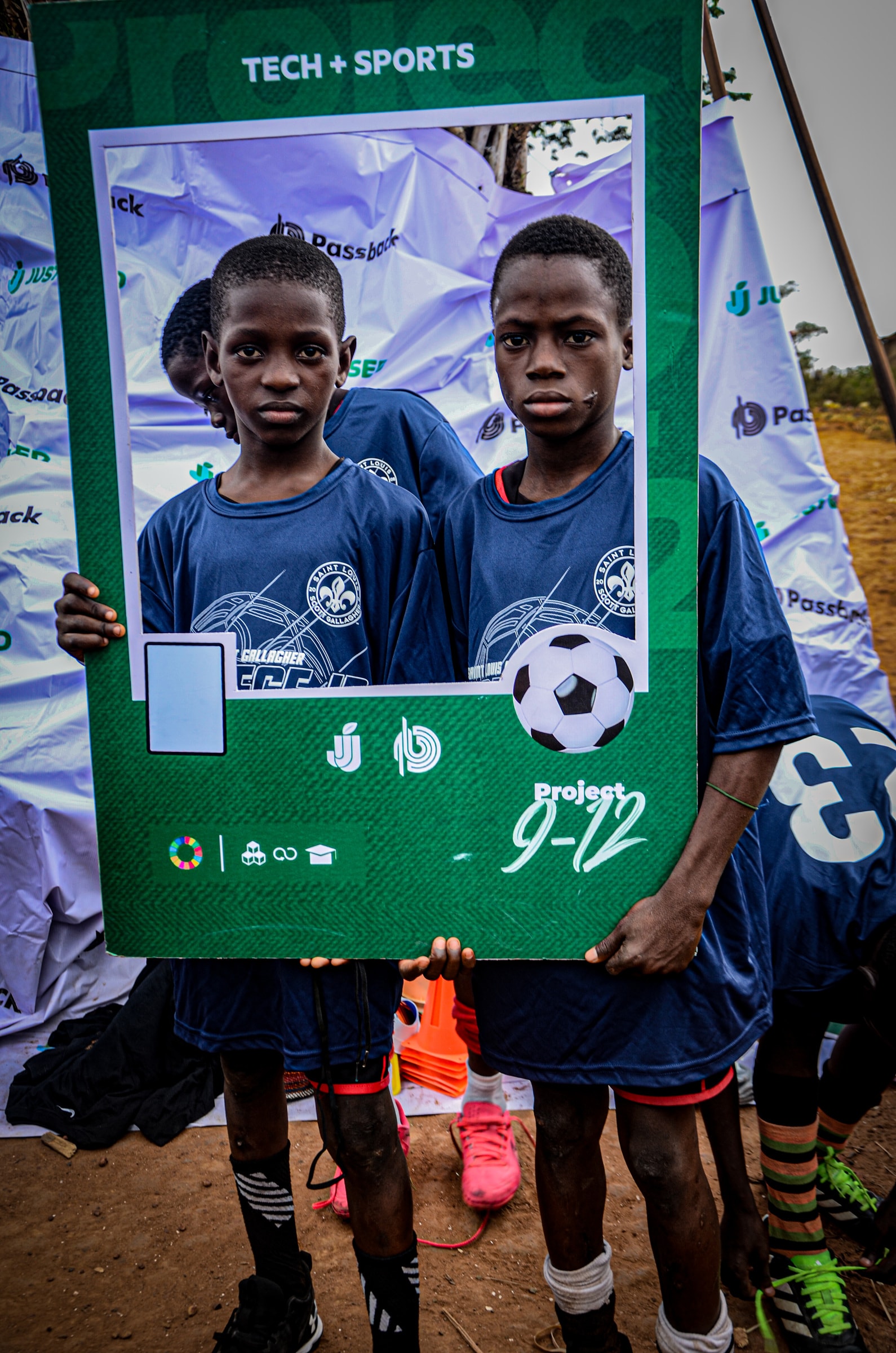 Two young players in team kit holding a Project 9-12 photo frame.